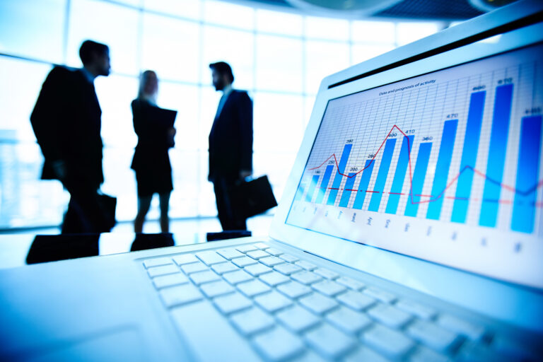 Mercado de capitais representado por análise de gráficos financeiros em ambiente corporativo.